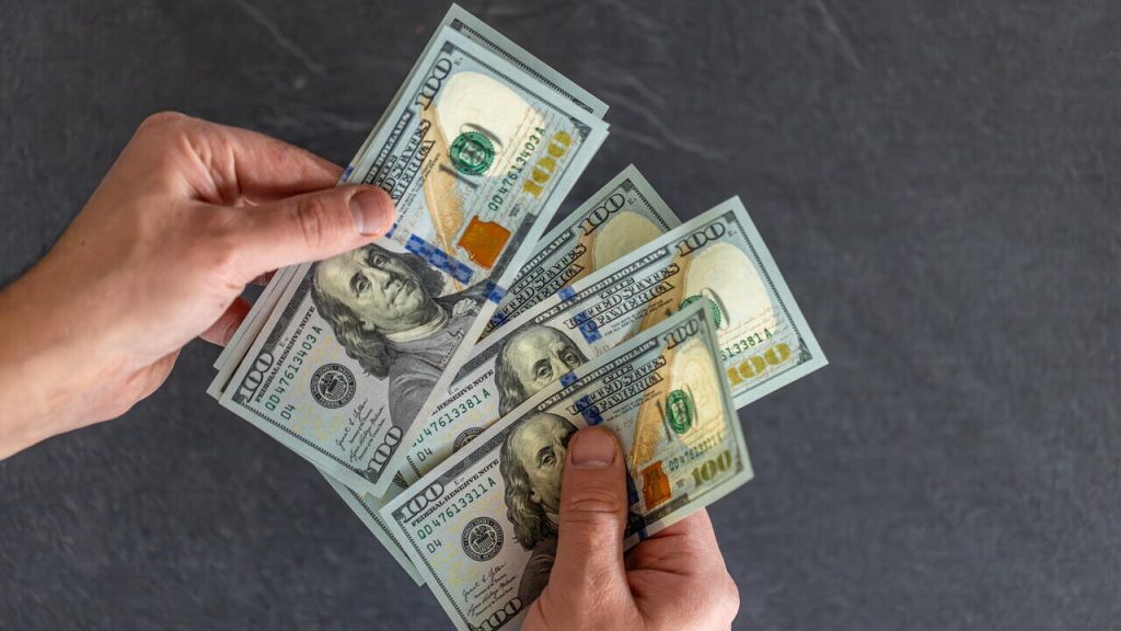 Hand holding money. international currency. exchange world money.